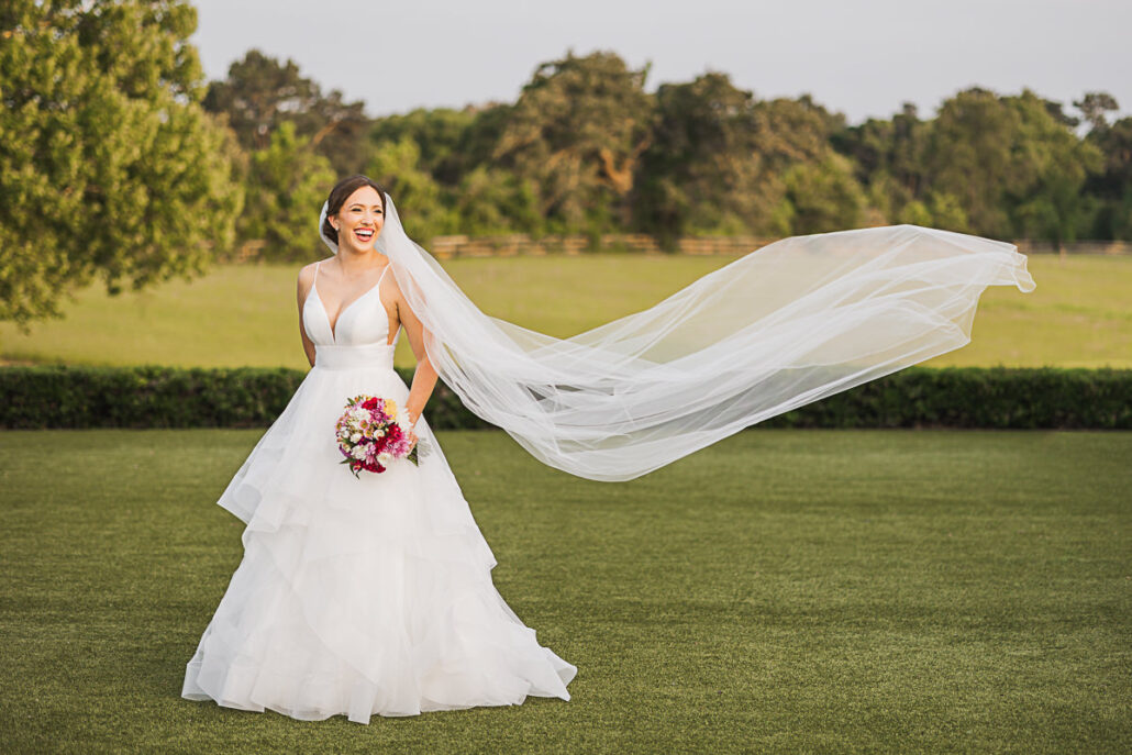 The Farmhouse Bridal Portrait - Nate Messarra Photography - Bride laughing with veil blowing in the wind