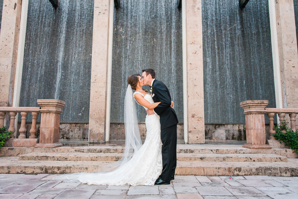 Bride and Groom dip kiss outside at Bell Tower on 34th Water Wall