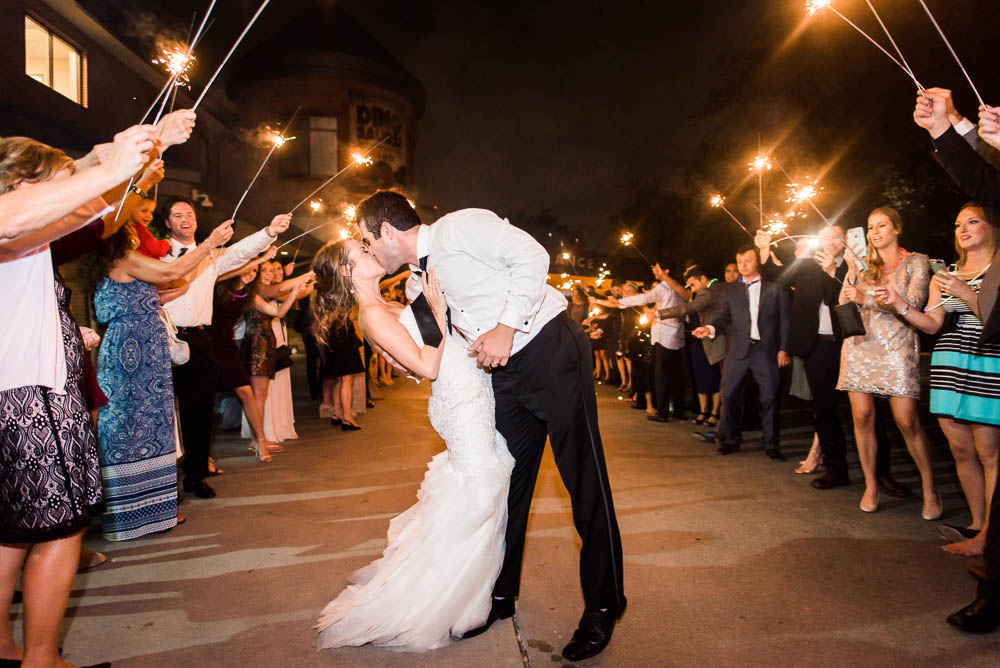 Bride and groom kissing during sparkler exit of their Houston Zoo Wedding