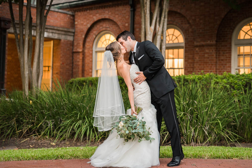 Bride and Groom kissing at First Presbyterian Church Houston courtyard for Houston Zoo Wedding